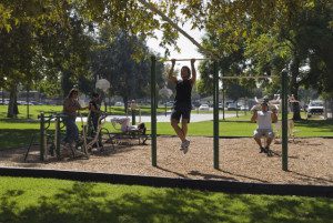 People exercising on outdoor gym equipment at Dalton Park in Azusa, California.
