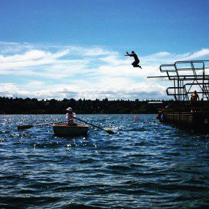 Boy jumps off diving board into Green Lake
