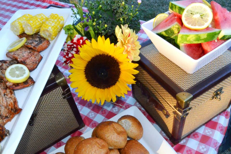salmon, rolls and watermelon on picnic table