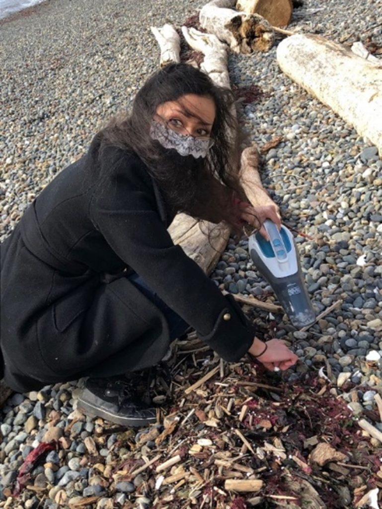 Volunteers use hand vacuums to suck up dried beads of Sytrafoam off the beach at Lincoln Park.
