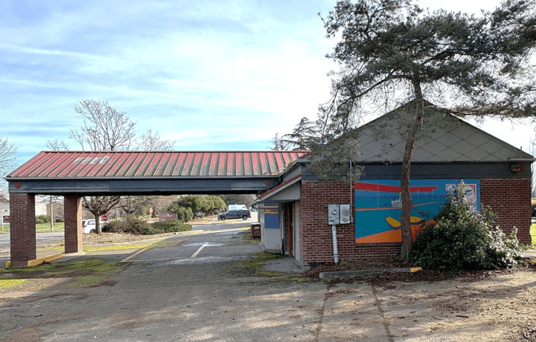 A brick building with a large covered entry way and a mural